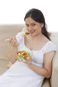 Pregnant woman eating fruits